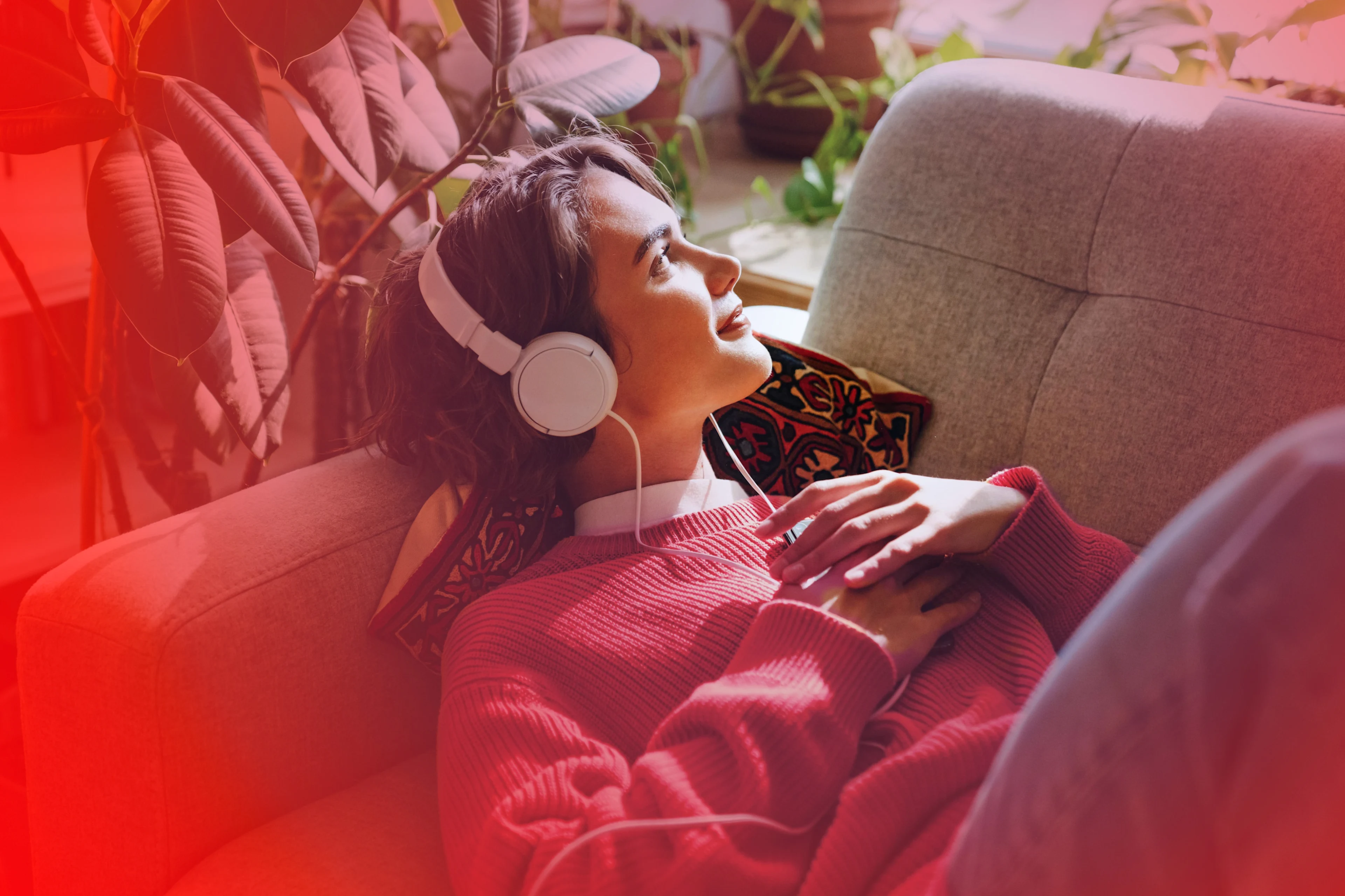 Frau mit Kopfhörern auf einer Couch